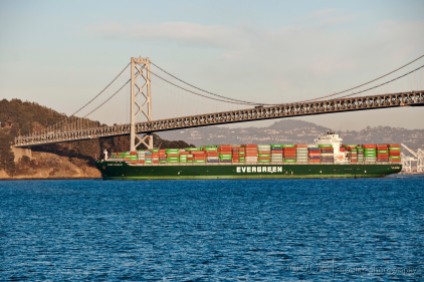 A colorful cargo ship on the move under the Bay Bridge...