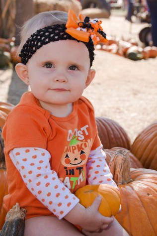 Her shirt says, Cutest Pumpkin in the patch. Awh!